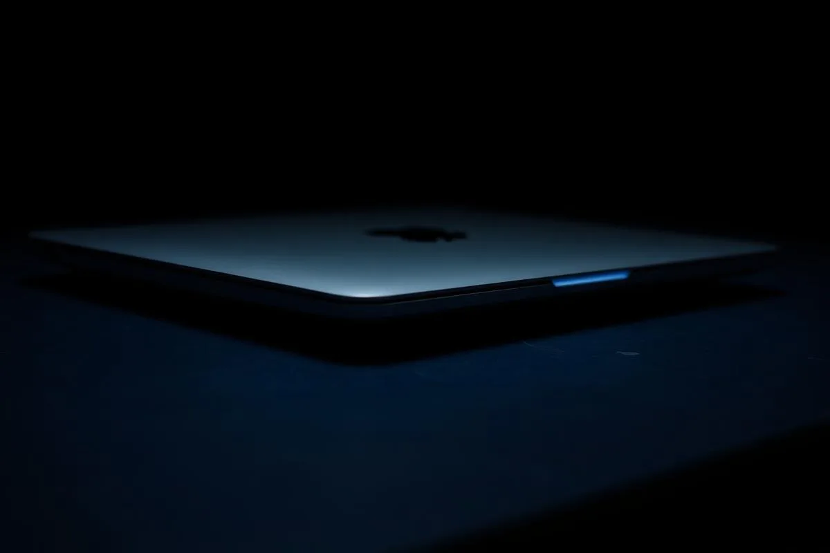 Closed MacBook Air on a dark surface with blue rim light — MacBook resale value UAE